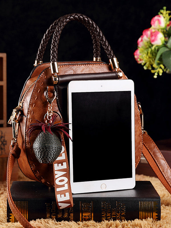 Vintage kožené kabelky kulatého tvaru se střapci. Taška přes rameno