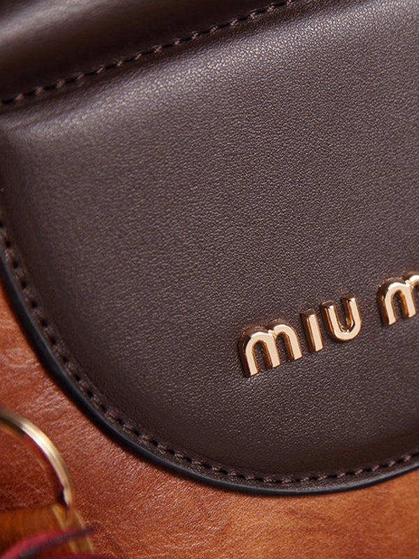 Vintage kožené kabelky kulatého tvaru se střapci. Taška přes rameno