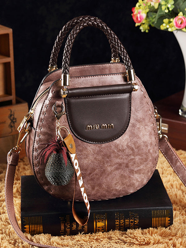 Vintage kožené kabelky kulatého tvaru se střapci. Taška přes rameno