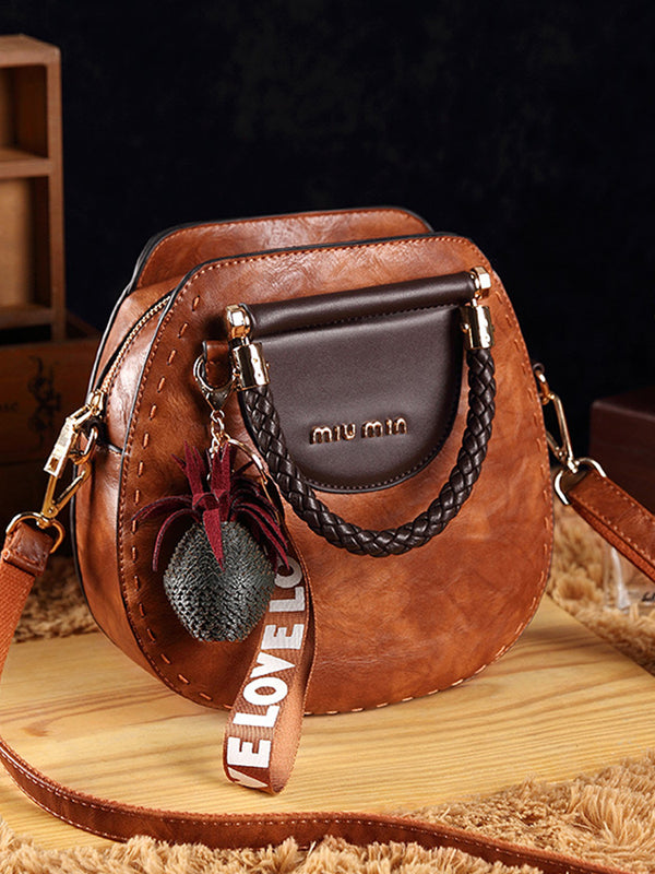 Vintage kožené kabelky kulatého tvaru se střapci. Taška přes rameno